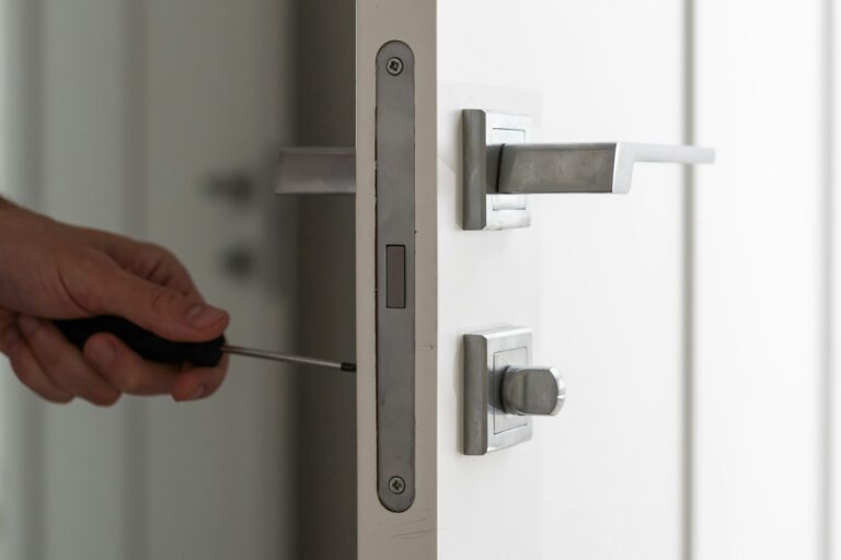 A locksmith is repairing an interior door lock. Close-up of male hands repairing or replacing an